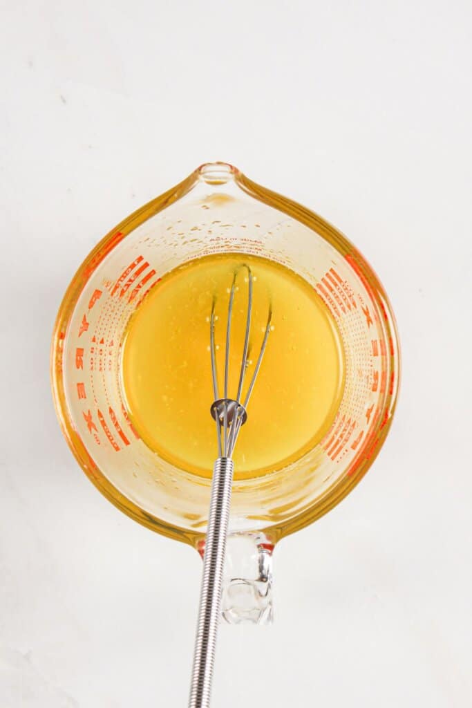 Dressing being mixed in a glass.