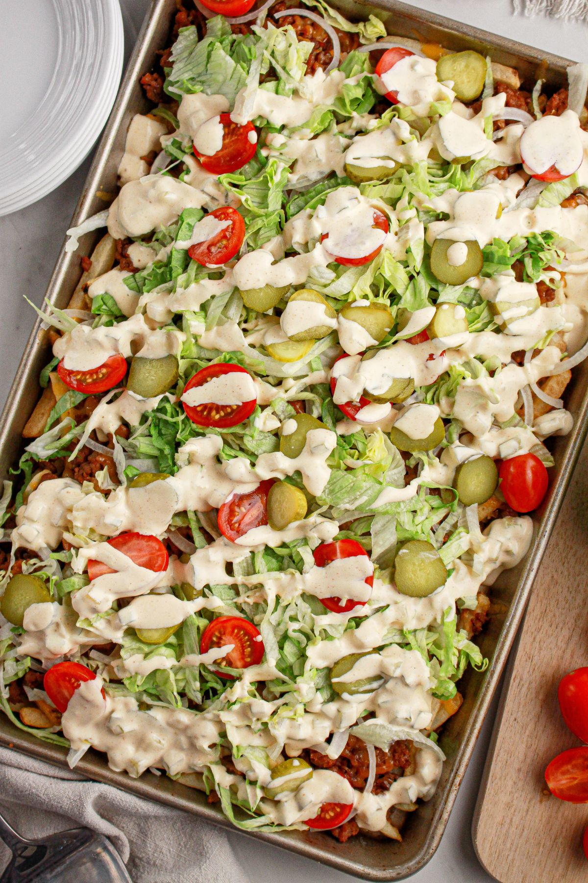 Dressing being drizzled on top of fries.