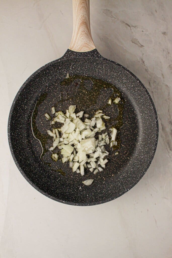 Onions being cooked in a skillet.