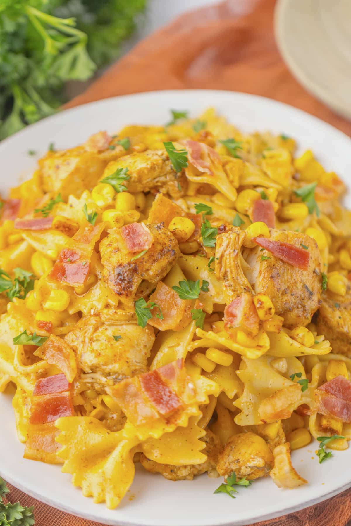 Plate full of chicken and corn pasta.