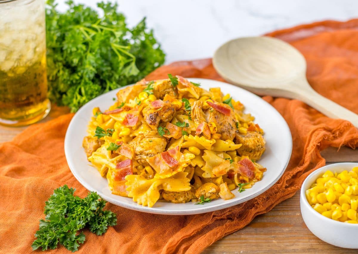 Plate full of chicken and corn pasta.