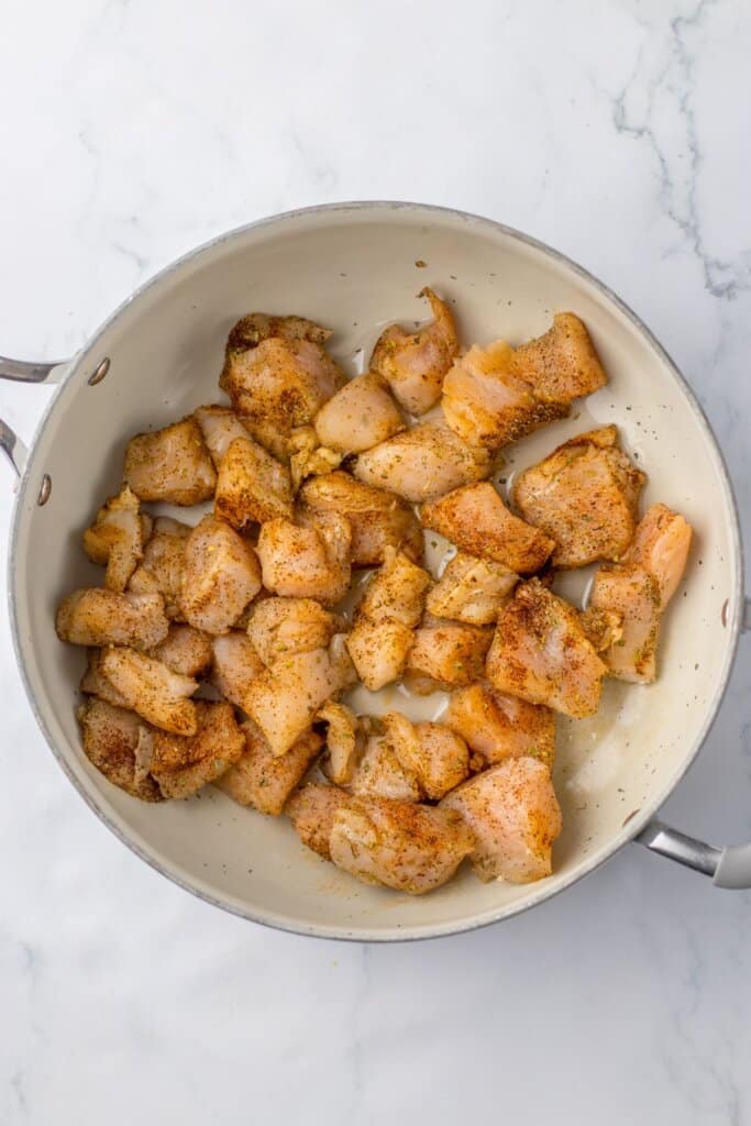Chicken being cooked in a large pot.