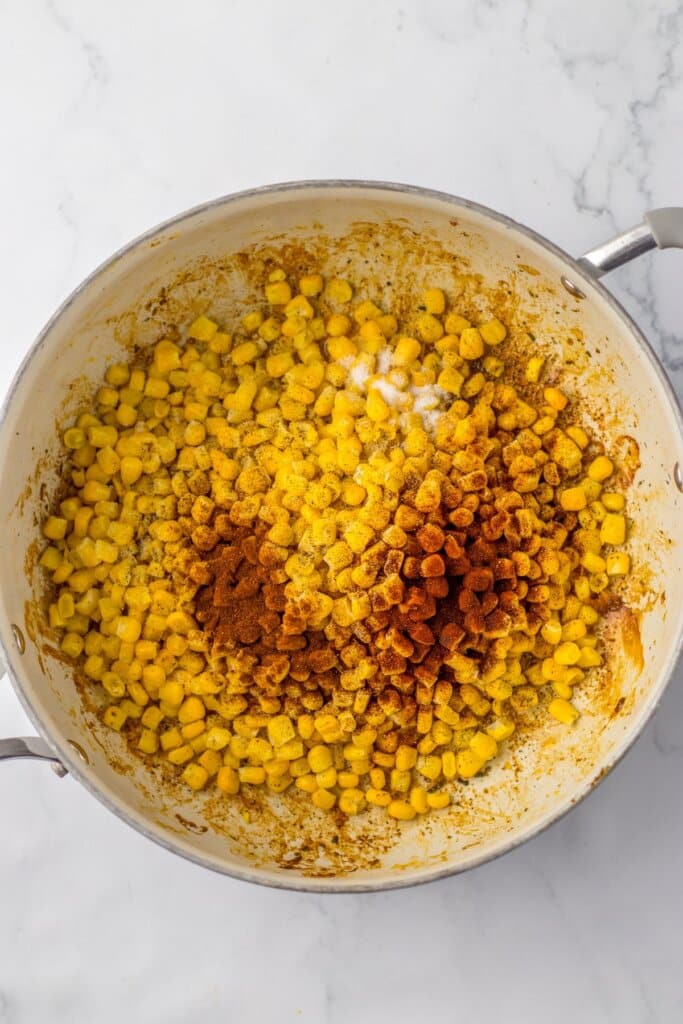 Corn and spices in a large skillet.