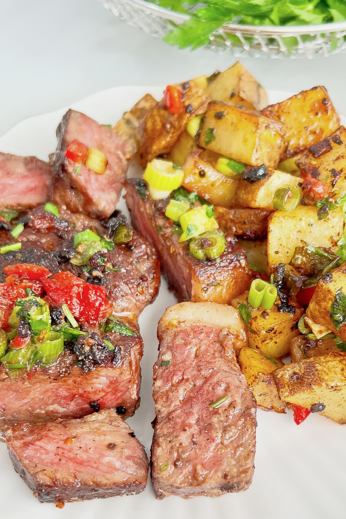 Steak and potatoes on a plate.