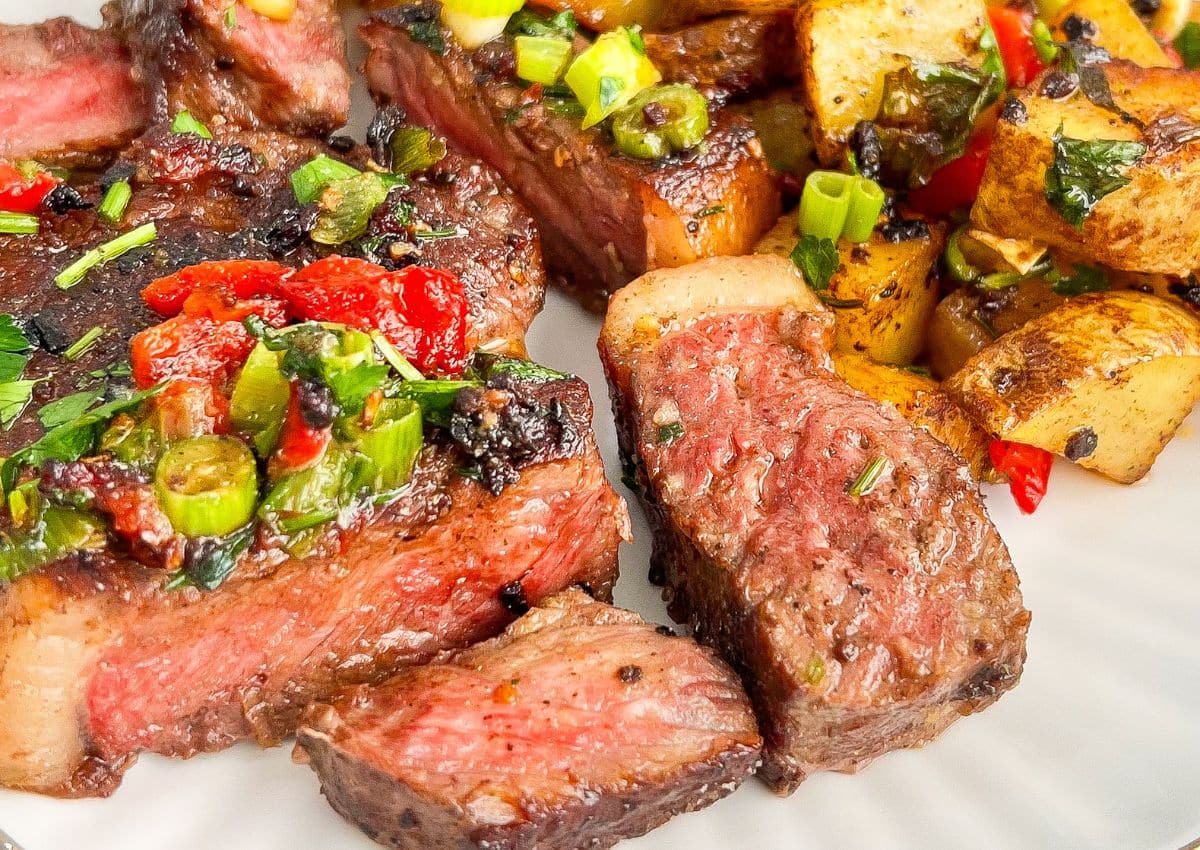 Steak and potatoes on a plate.