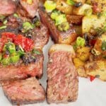 Steak and potatoes on a plate.