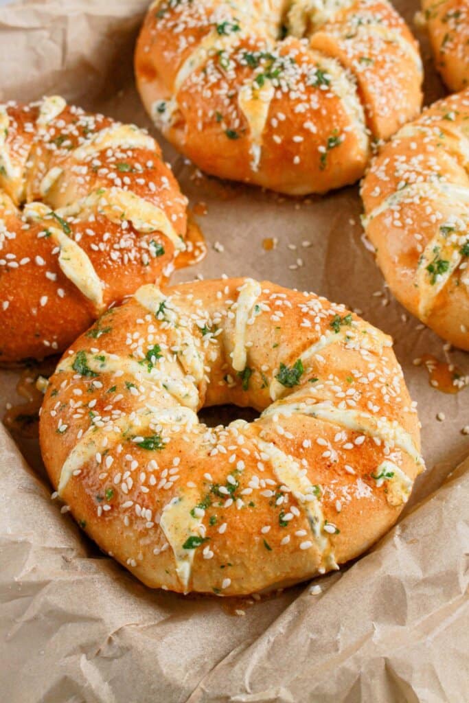 Bagels topped with sesame seeds on a baking dish.