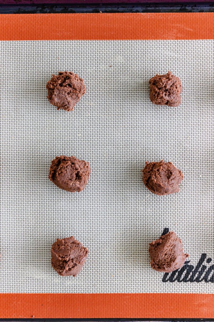 Dough balls on a silicone baking sheet.
