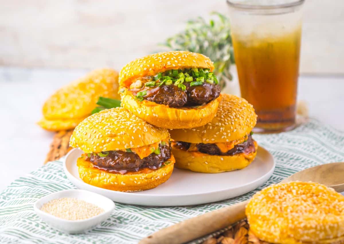 Three korean burgers on a plate.