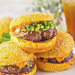 Three korean burgers on a plate.