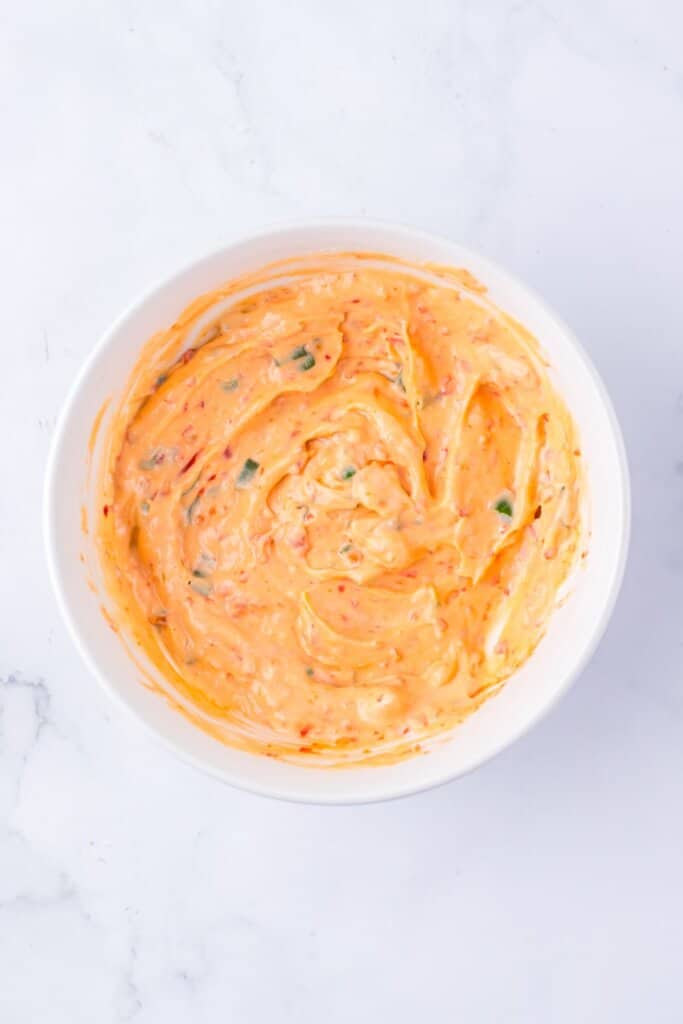 Mayo and sweet chili sauce being mixed in a bowl.