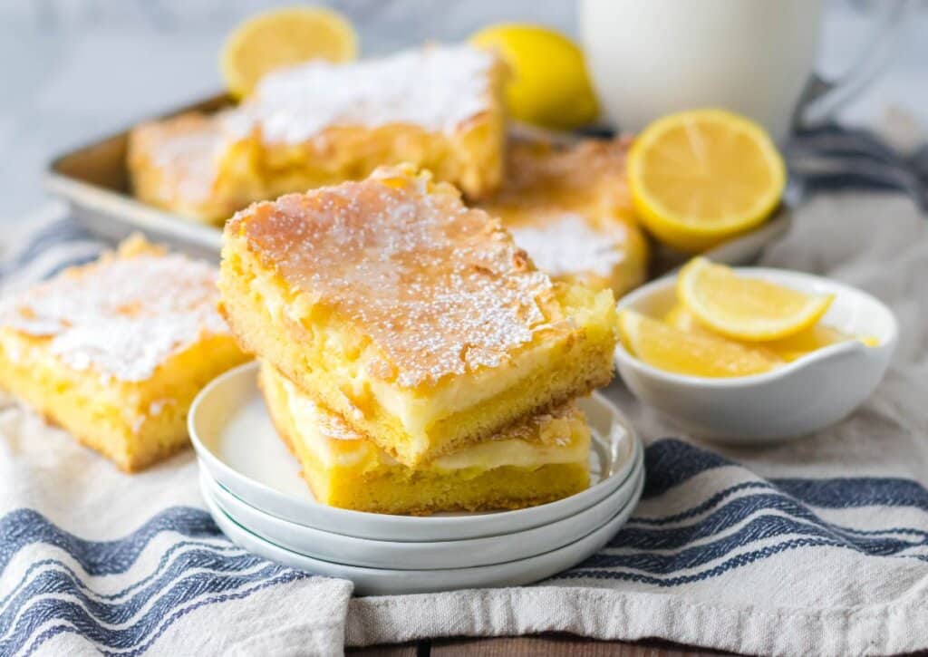 Two slices of lemon gooey butter cake on a plate.