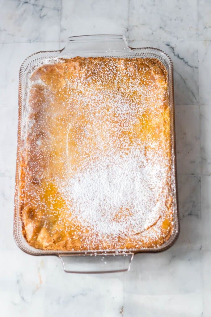 Powdered sugar being sprinkled on top of dessert.