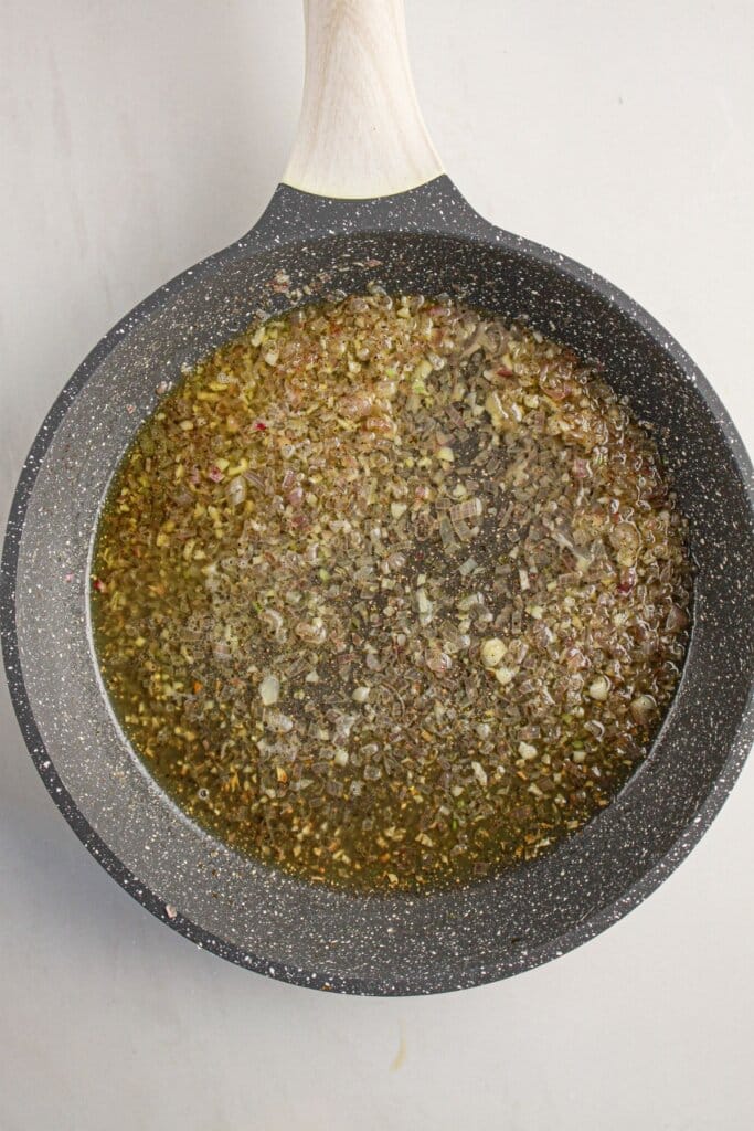 Vodka being added to a skillet.