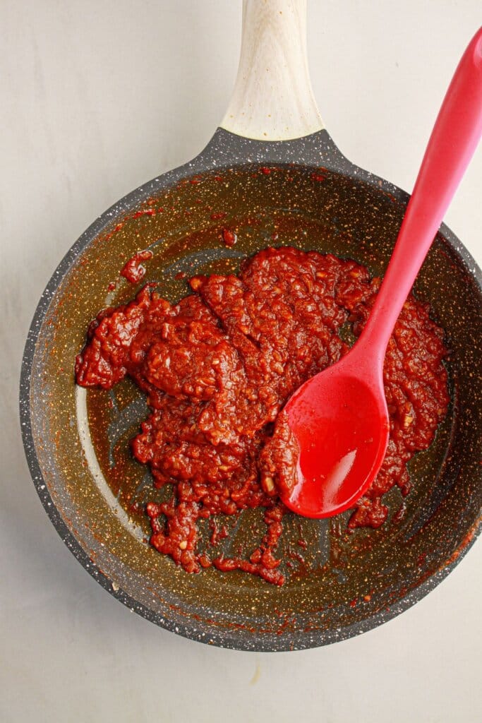 Tomato sauce being cooked down in a skillet.