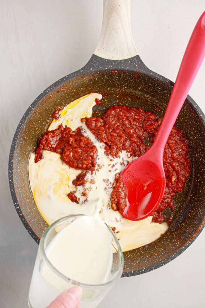 Heavy cream being added to a skillet.
