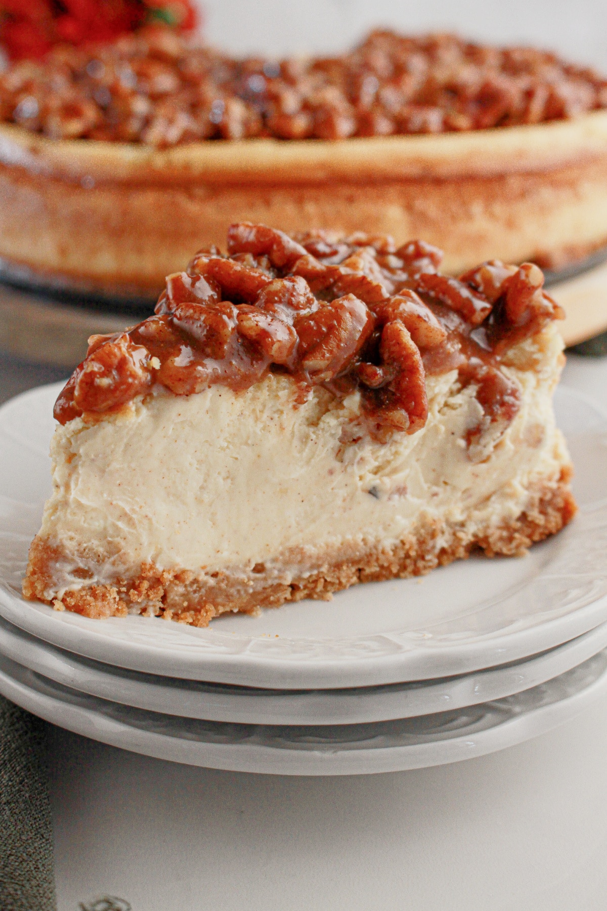 Slice of pecan pie cheesecake on a plate.