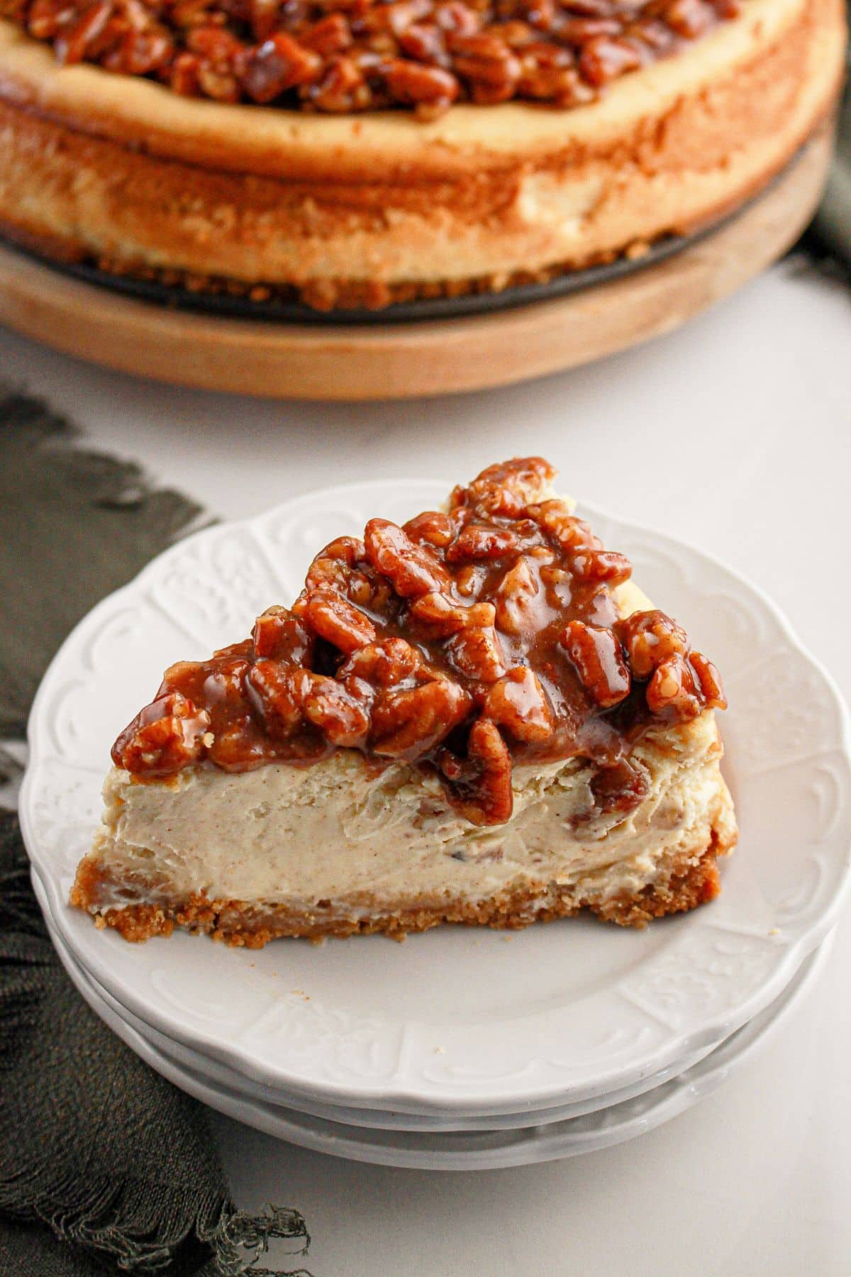 Slice of pecan pie cheesecake on a plate.
