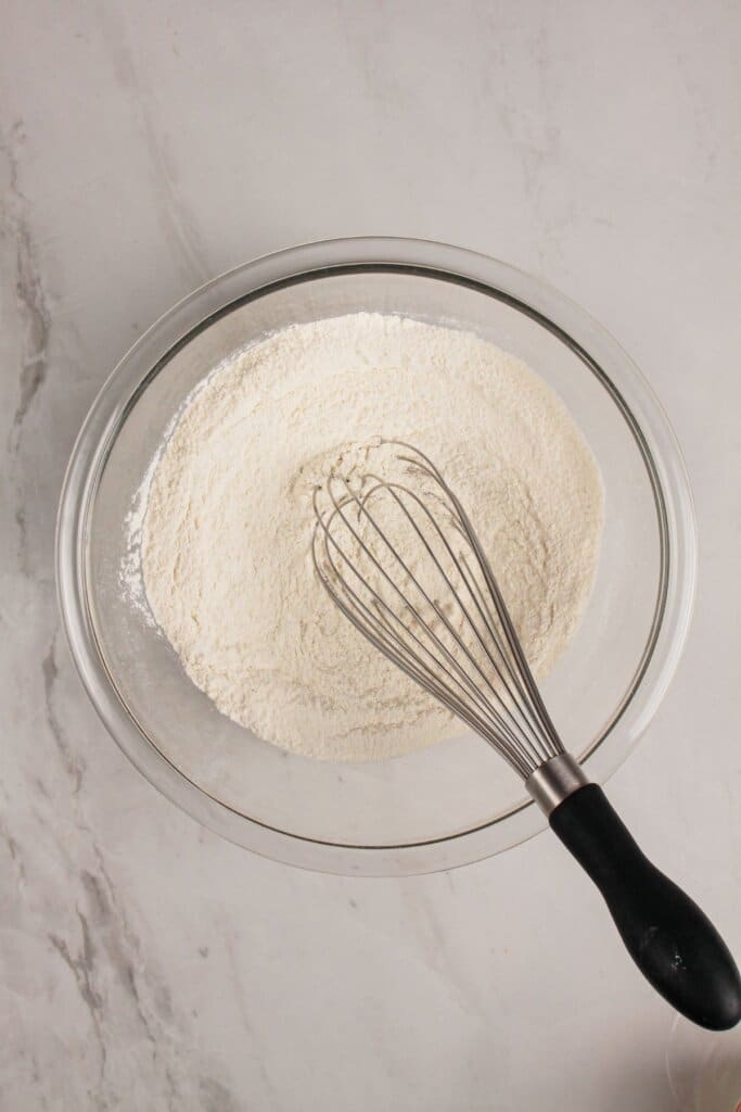 Dry ingredients being mixed in a glass bowl.