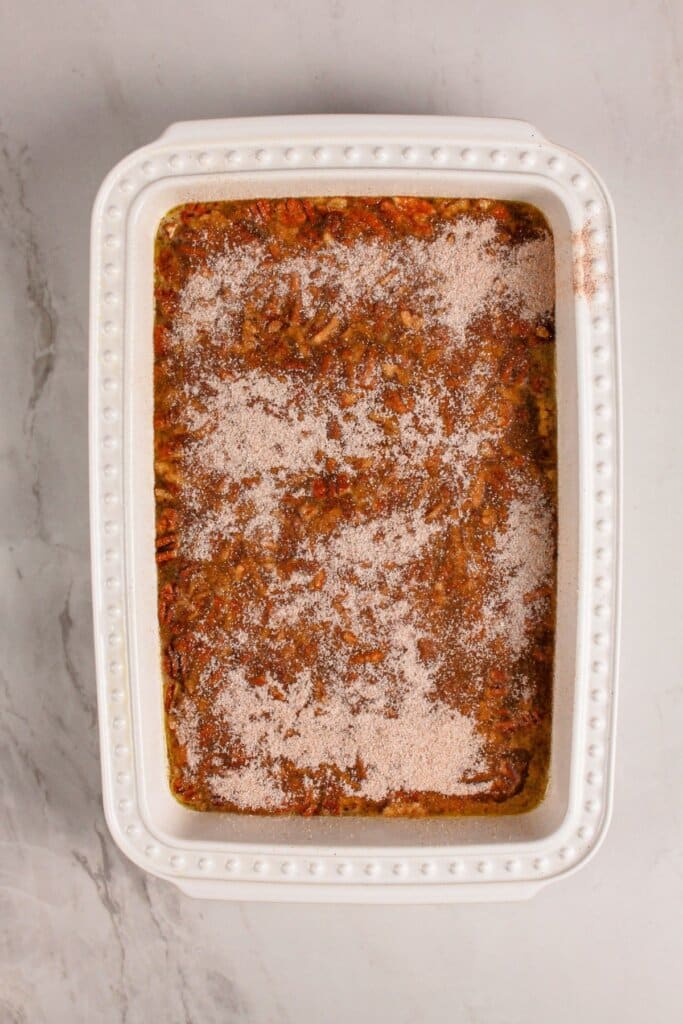 Cinnamon sugar being sprinkled on top of a dessert.