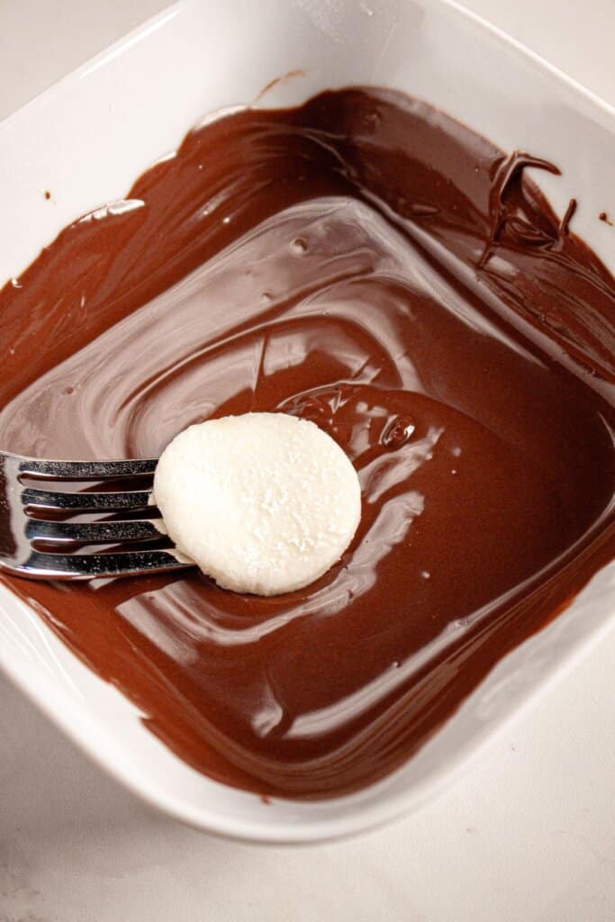 Filling being dipped in chocolate with a fork.