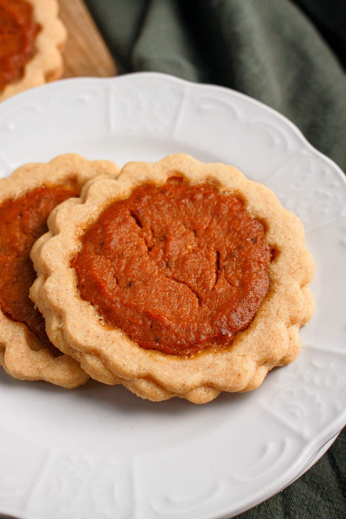 Two pumpkin pie cookies on a plate.