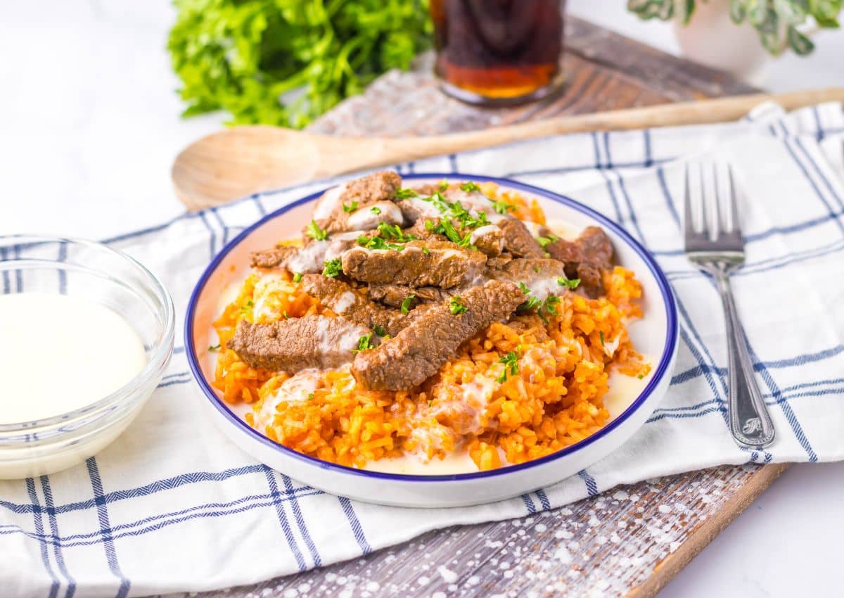 Plate full of queso steak and rice.