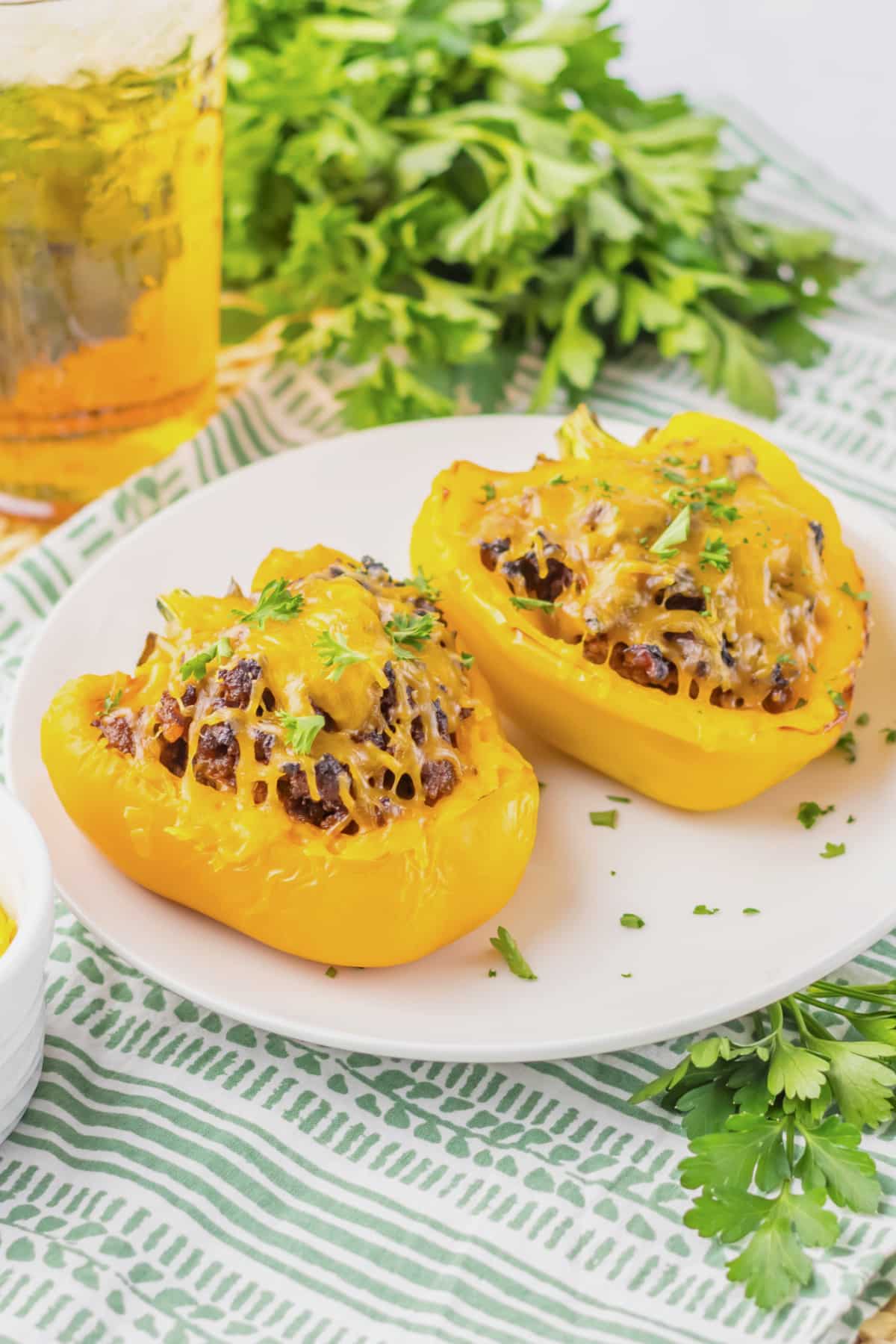 Two sloppy joe stuffed peppers on a plate.