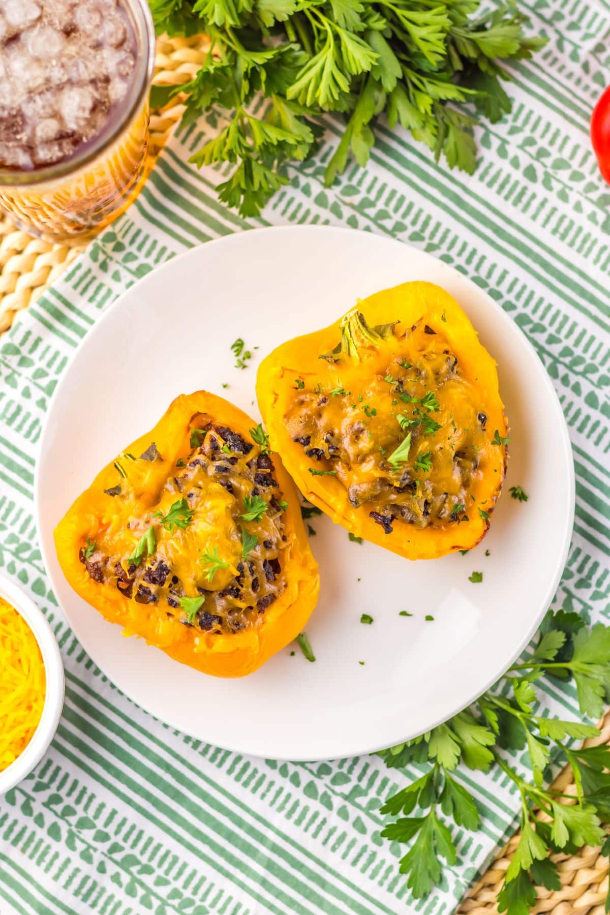Two sloppy joe stuffed peppers on a plate.