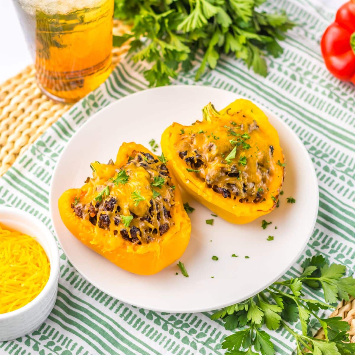 Two sloppy joe stuffed peppers on a plate.