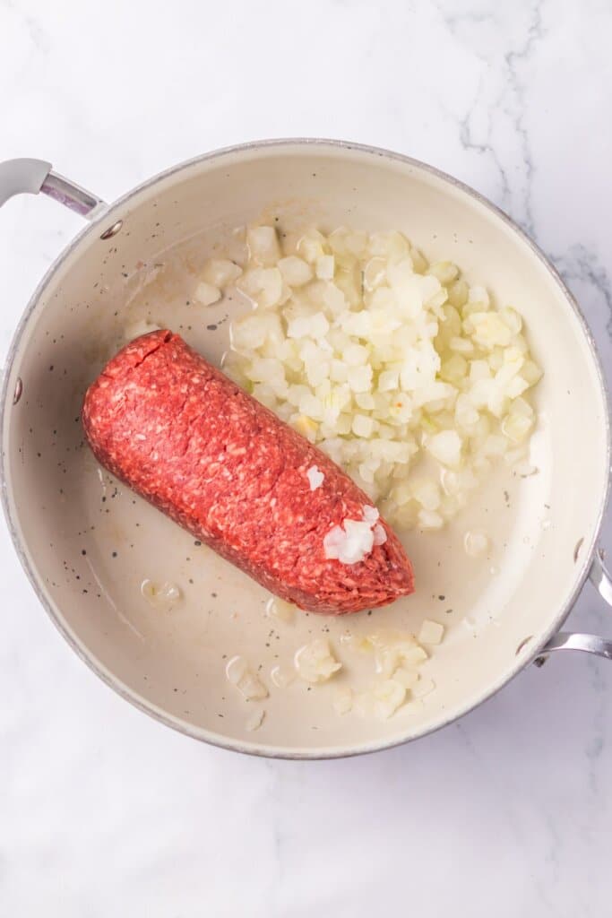 Ground beef and onions in a skillet.