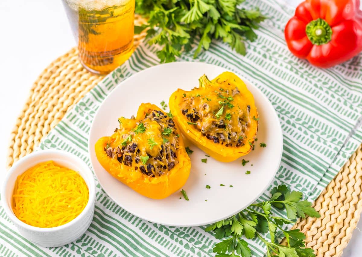 Two sloppy joe stuffed peppers on a plate.
