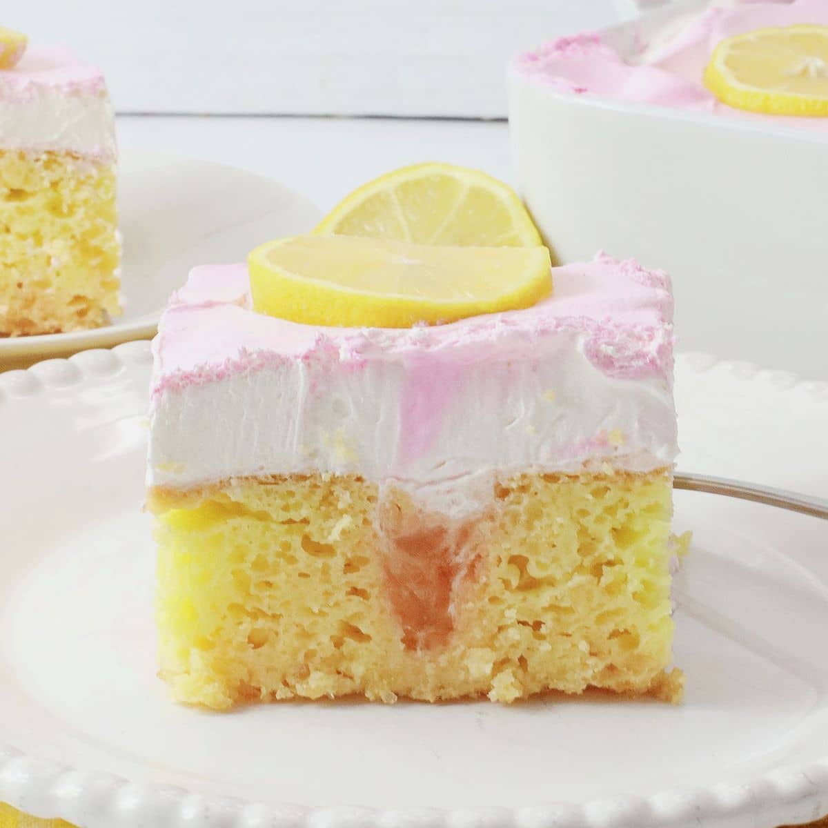 Slice of watermelon poke cake on a plate.