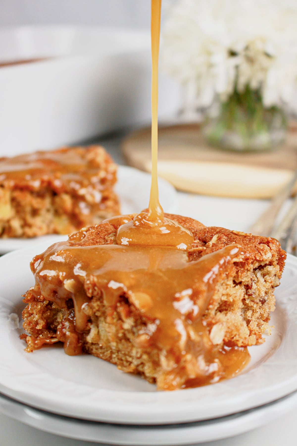 Slice of apple pecan cake on a small plate.