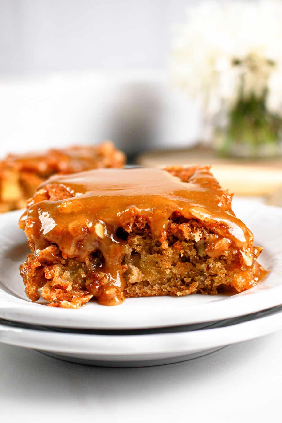 Slice of apple pecan cake on a small plate.