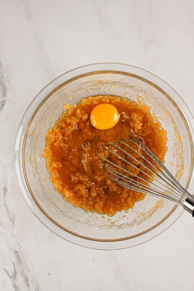 Wet ingredients being mixed in a glass bowl.