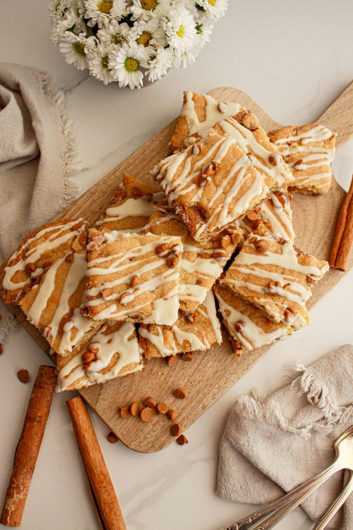 Cinnamon chip cookie bars stacked on a wooden cutting board.
