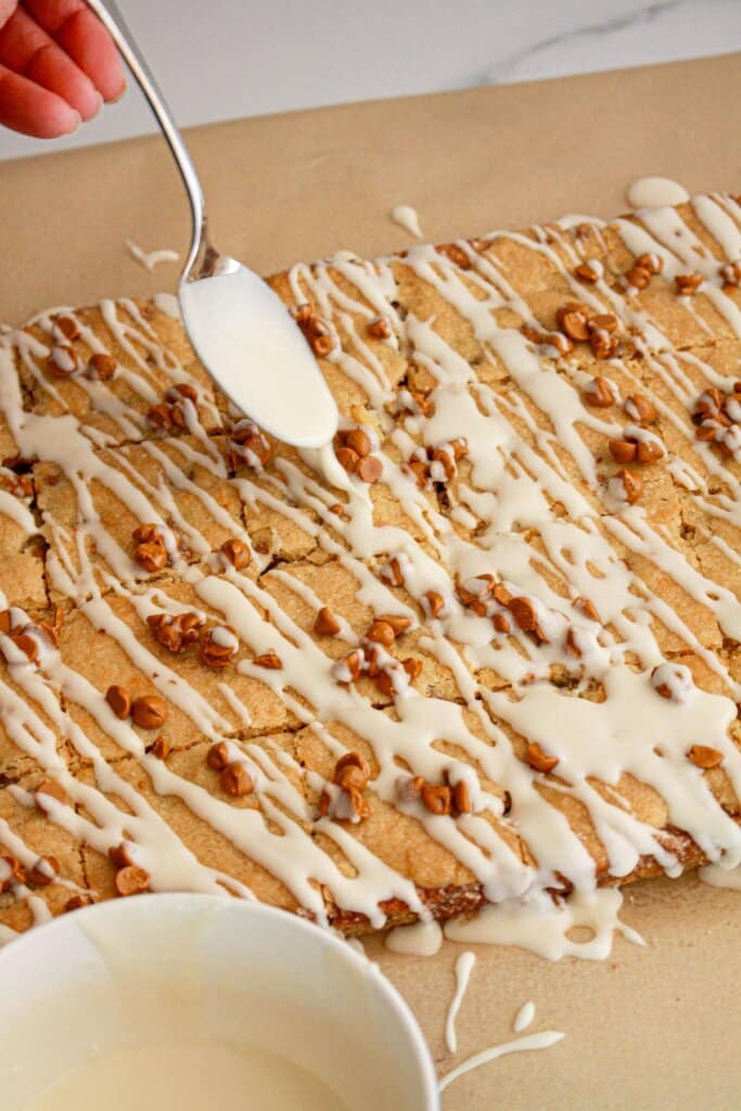 Glaze being drizzled on dessert bars.