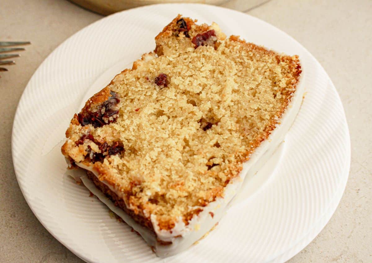 Slice of cranberry white chocolate bread on a plate.
