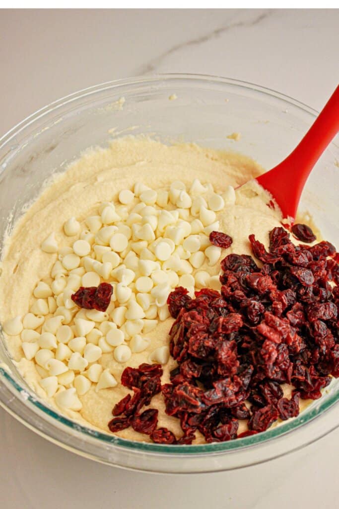 White chocolate chip and cranberries in a mixing bowl.