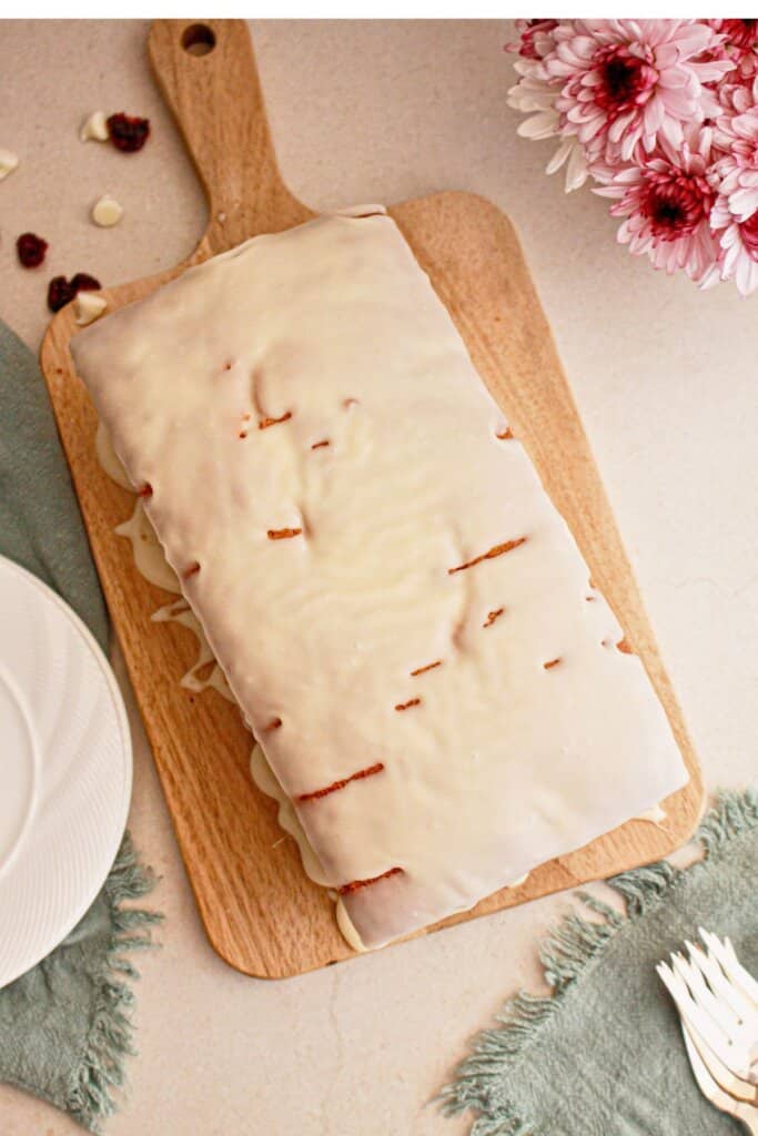 Cranberry white chocolate bread on a wooden cutting board.