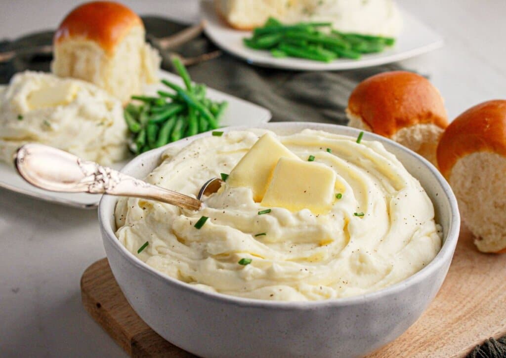 White bowl full of cream cheese mashed potatoes.
