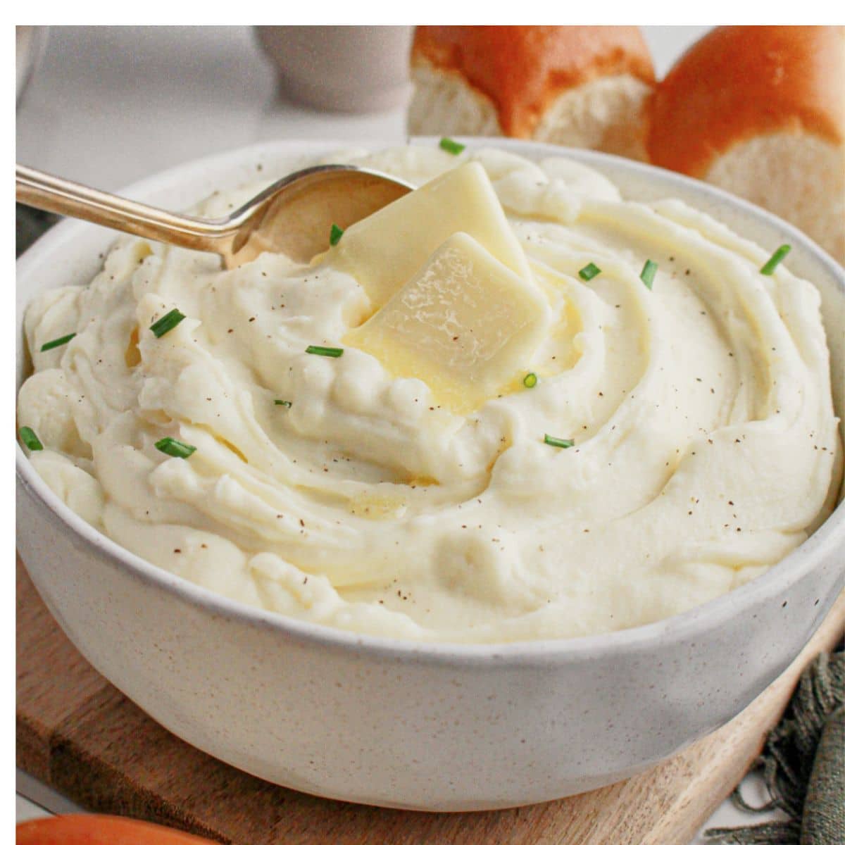 White bowl full of cream cheese mashed potatoes.