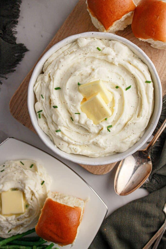 White bowl full of cream cheese mashed potatoes.