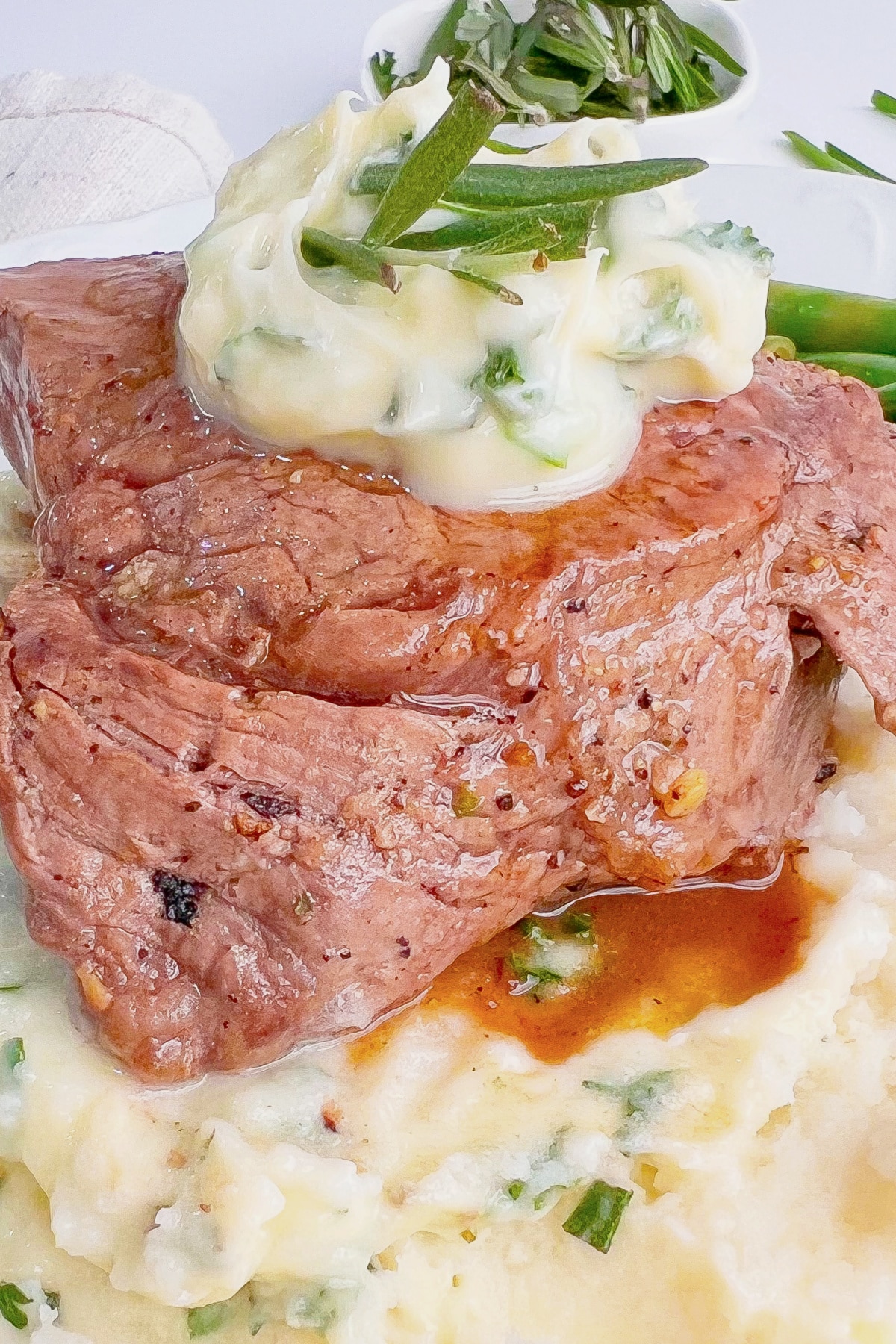 Herb butter filet mignon on a plate.