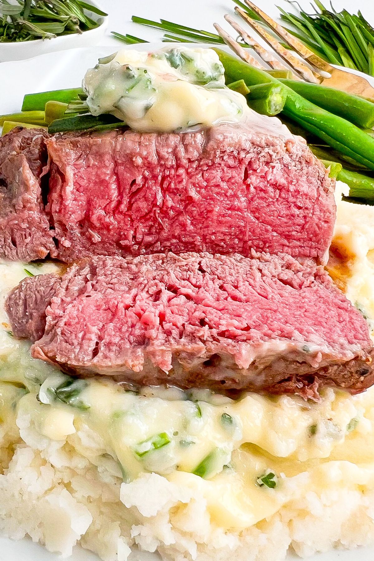 Herb butter filet mignon on a plate.