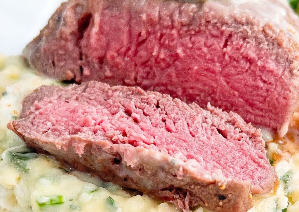 Herb butter filet mignon on a plate.