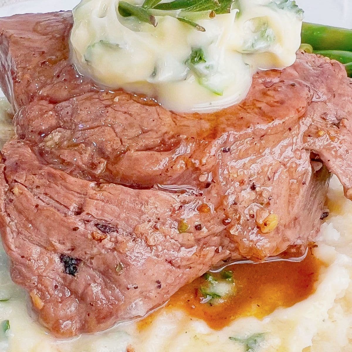 Herb butter filet mignon on a plate.