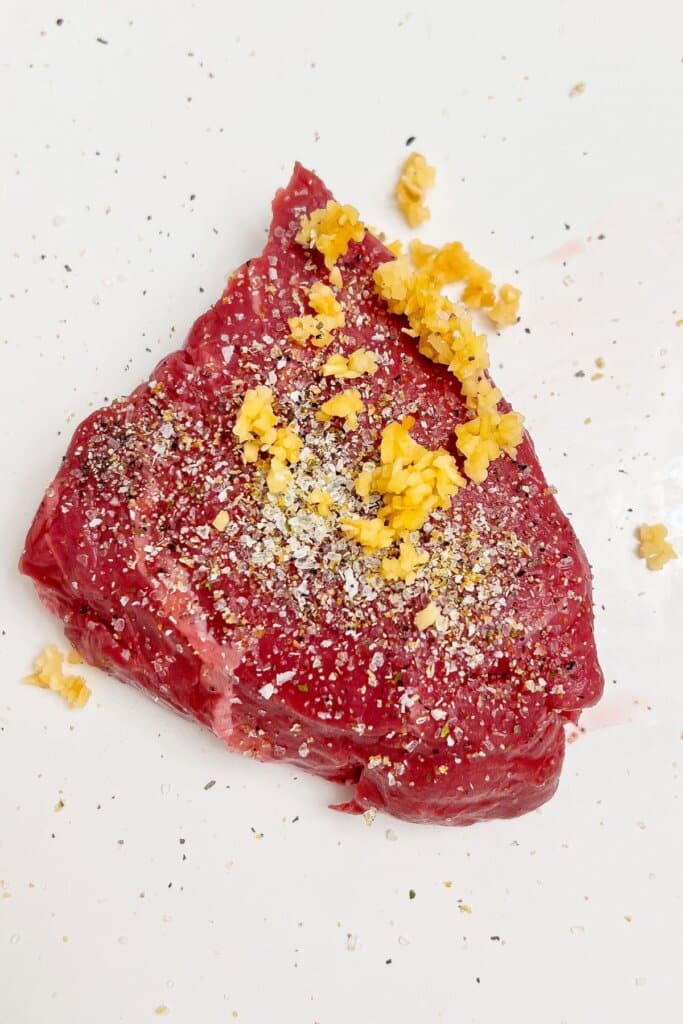 The steak is being seasoned.