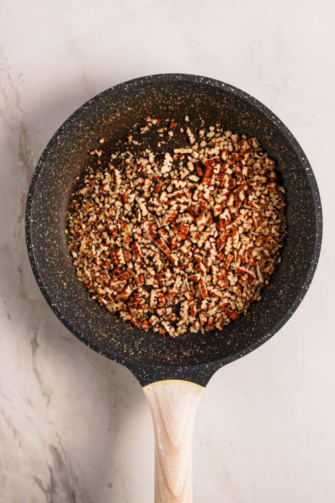Pecans being toasted in a skillet.